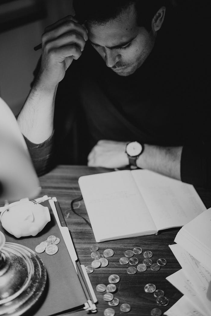 Crop pondering man analyzing expenses and taking notes